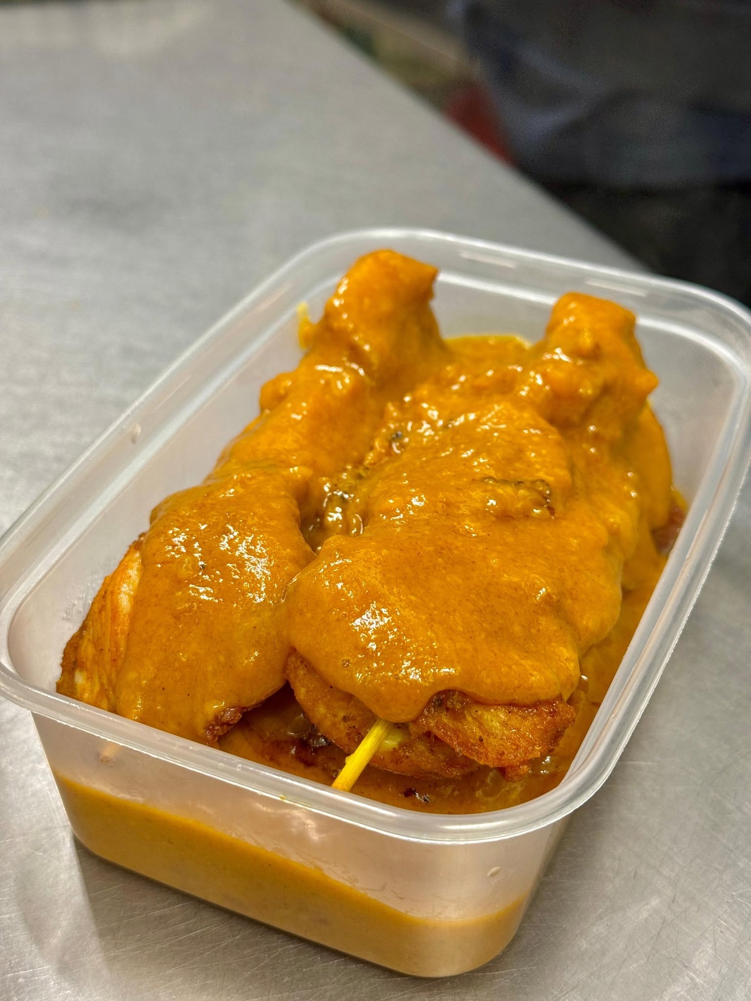 Satay chicken on skewers covered in rich satay sauce