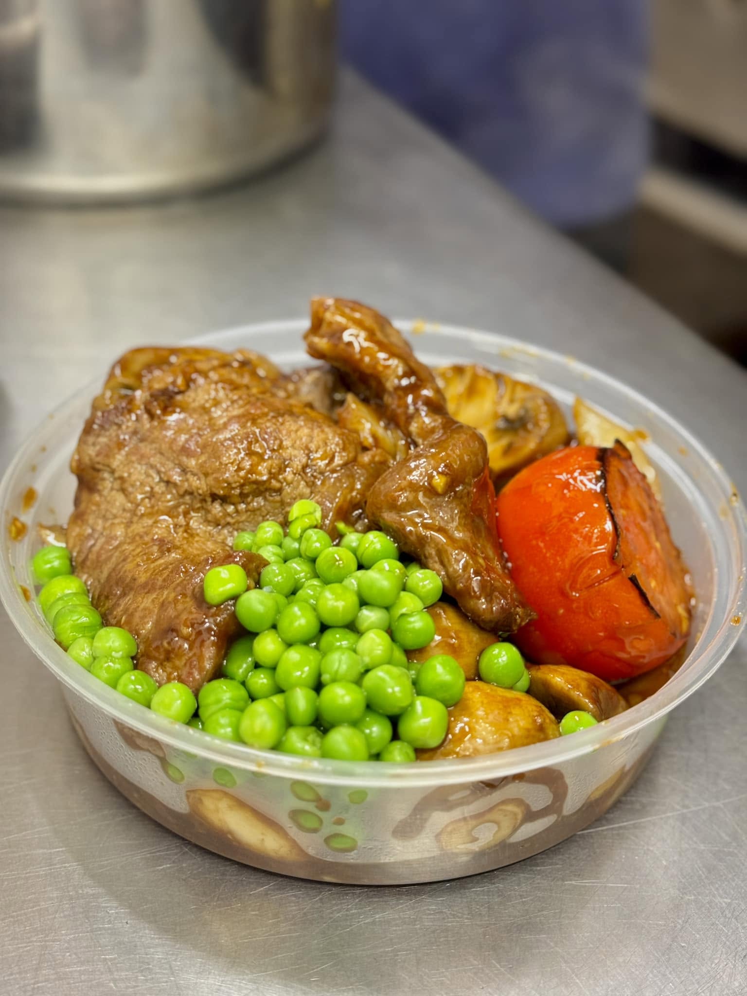 Sirloin steak dinner with peas, mushrooms and grilled tomato